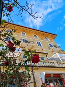 a yellow building with roses in front of it at Hotel Canali, Portofino Coast in Rapallo