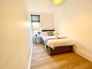 Duas camas num pequeno quarto com uma janela em Huge serviced Apartment with FREE PARKING em Jesmond