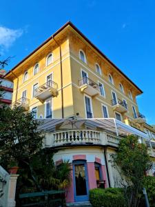 a yellow and white building with a balcony at Hotel Canali - Le Cinque Terre in Rapallo