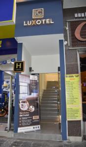 a store entrance with stairs and a sign in front at Hotel Luxotel Chincha in Chincha Alta