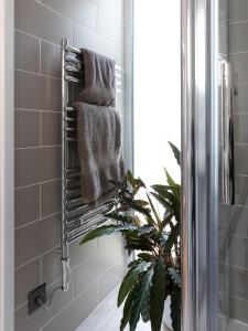 a towel rack in a bathroom with a mirror at Owl and Dragon Studio in Totnes