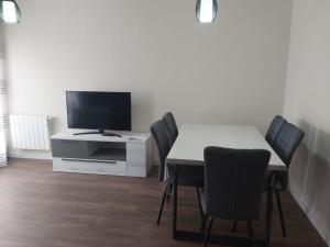 a dining room with a table with chairs and a tv at CORRAL DEL DUQUE II in San Cristóbal de Segovia
