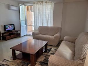 uma sala de estar com um sofá e uma mesa de centro em Apartment Rose Mamaia Nord Summerland em Mamaia