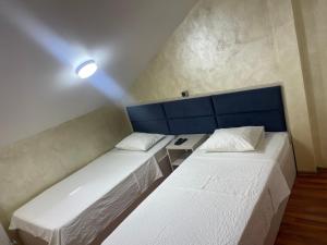 a room with two beds and a blue headboard at KM 80 Restaurant & Hotel in Mavrodolu