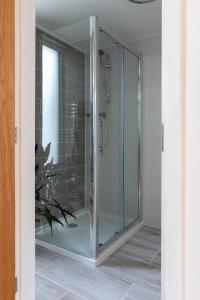 a glass shower stall in a bathroom with at Owl and Dragon Studio in Totnes