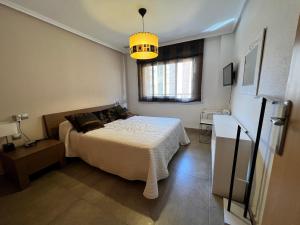 a bedroom with a bed and a yellow light at APARTAMENTO LA MATA in La Mata