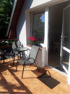 a patio with chairs and a table and a window at Przy morzu in Jarosławiec
