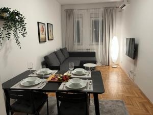 un soggiorno con tavolo e divano di Apartment Ana - City Center a Belgrado