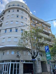 um edifício alto e branco com uma placa de estacionamento em frente em Apartment Ana - City Center em Belgrado