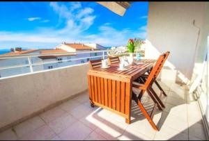 balcón con mesa de madera y vistas al océano en Apartment Diana, en Split