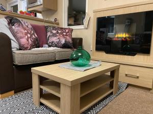 a living room with a couch and a table at Prestige caravan,Seton Sands holiday village, WiFi in Port Seton