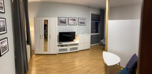salon z telewizorem w białej szafce w obiekcie Mona Wrzeszcz w Gdańsku