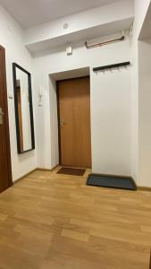 een lege kamer met een deur en een houten vloer bij Mona Wrzeszcz in Gdańsk