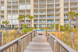 a boardwalk leading to a resort with a building at Bluewater in Orange Beach