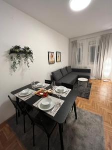 uma sala de estar com uma mesa e um sofá em Apartment Ana - City Center em Belgrado