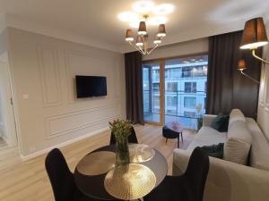 a living room with a couch and a table at Masuria Apartaments Ełk Symfonia in Ełk