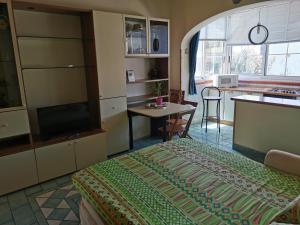 a bedroom with a bed and a table and a kitchen at Monolocale Ischia Isola Verde in Ischia Town