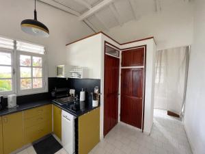 a kitchen with a sink and a red door at Bungalow Les Gommiers in Saint-François