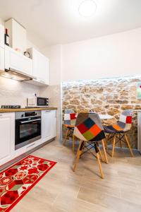 a kitchen with a table and chairs and a stone wall at Studio apartman Mirela Kaštel Štafilić in Kaštela