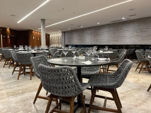 a restaurant with tables and chairs with wine glasses at Salinas Premium Resort in Salinópolis