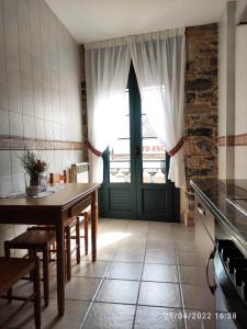 a kitchen with a table and a green door at Apartamento Campomanes in Villaviciosa