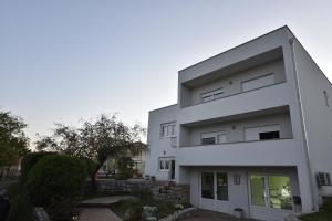 a white building with a lot of windows at Apartmani JURIĆ in Međugorje