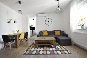 a living room with a couch and a table at Apartmani JURIĆ in Međugorje