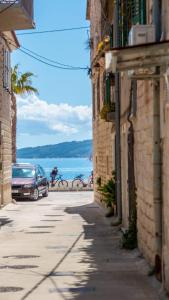 a street with cars parked on the side of a building at Studio apartman Mirela Kaštel Štafilić in Kaštela
