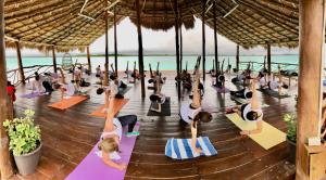 un gruppo di persone che fanno yoga sulla spiaggia di Akalki Hotel y Centro Holistico a Bacalar