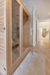 a large glass shower in a room with a hallway at Gold Apartment Szczecinek in Szczecinek +22 photos
