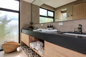 Un baño con encimera con lavabo y espejo. en Luxury Beachfront Villa with private pool at Nantipa, en Santa Teresa Beach