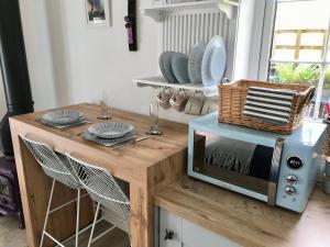 a table with a microwave on top of it at The Bothy - your unique luxury refuge in Saint Fillans