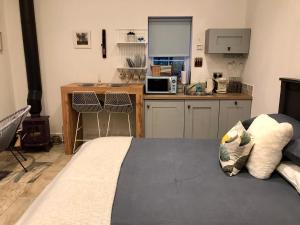 um quarto com uma cama e uma cozinha com um fogão em The Bothy - your unique luxury refuge em Saint Fillans
