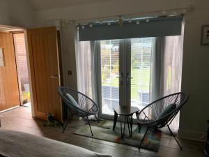 um quarto com 2 cadeiras e uma mesa em frente a uma janela em The Bothy - your unique luxury refuge em Saint Fillans