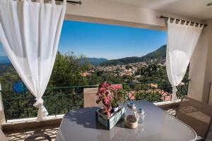 a table with flowers on top of a balcony at Casa De Blue in Kariá