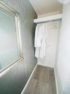 a white closet with a window and a white robe at BayBreeze Apartment The Hoe in Plymouth