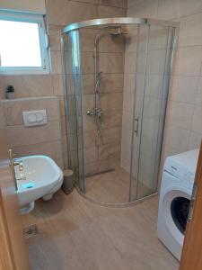 a shower in a bathroom with a sink and a washing machine at Bella Vista in Komarna