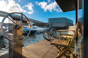 ein Fahrrad auf einem Steg mit einer Bank und einem Boot in der Unterkunft Oporto Douro Floating House in Porto