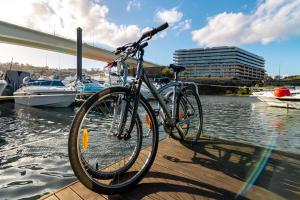 een fiets geparkeerd op een steiger naast het water bij Oporto Douro Floating House in Porto