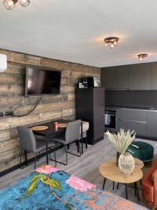 a living room with a table and chairs and a kitchen at Tiny House in Westdorpe