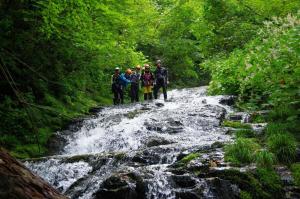 a group of people walking across a stream at Minpaku Taki - Vacation STAY 12843 in Gero