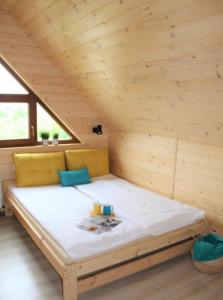 a large bed in a room with a wooden ceiling at Morza szum in Karwia