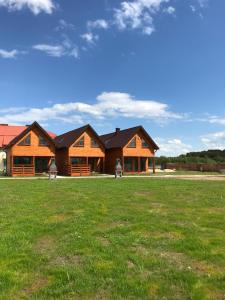 ein großes Haus mit einem Grasfeld davor in der Unterkunft Morza szum in Karwia