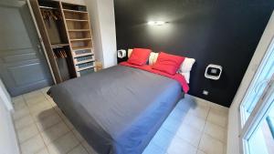 a bedroom with a bed with red pillows on it at L'Atalante, 2 pièces 47m2 rénové résidence piscine in Villeneuve-Loubet +15 photos