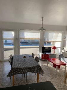 een woonkamer met een tafel en een bank bij Petite escapade à la Picardière in Fort-Mahon-Plage