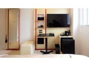 een slaapkamer met een bureau en een tv aan de muur bij Center Hotel Narita 2 R51 - Vacation STAY 43386v in Narita