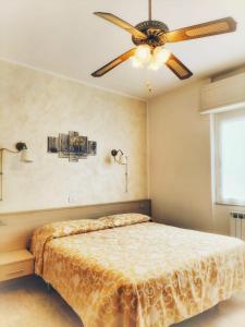 Schlafzimmer mit einem Bett und einem Deckenventilator in der Unterkunft B&B Hotel Costa Azzurra in Spotorno