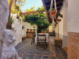 un patio con mesa y sillas en una casa en La Era de San Blas, en Fuentes de León
