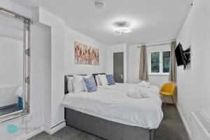 a bedroom with a large white bed with a window at 4 Bed - Smeatons by Pureserviced in Plymouth