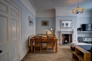 a dining room with a table and chairs and a fireplace at NEW Grade 2 historic flat in the heart of Chester in Chester